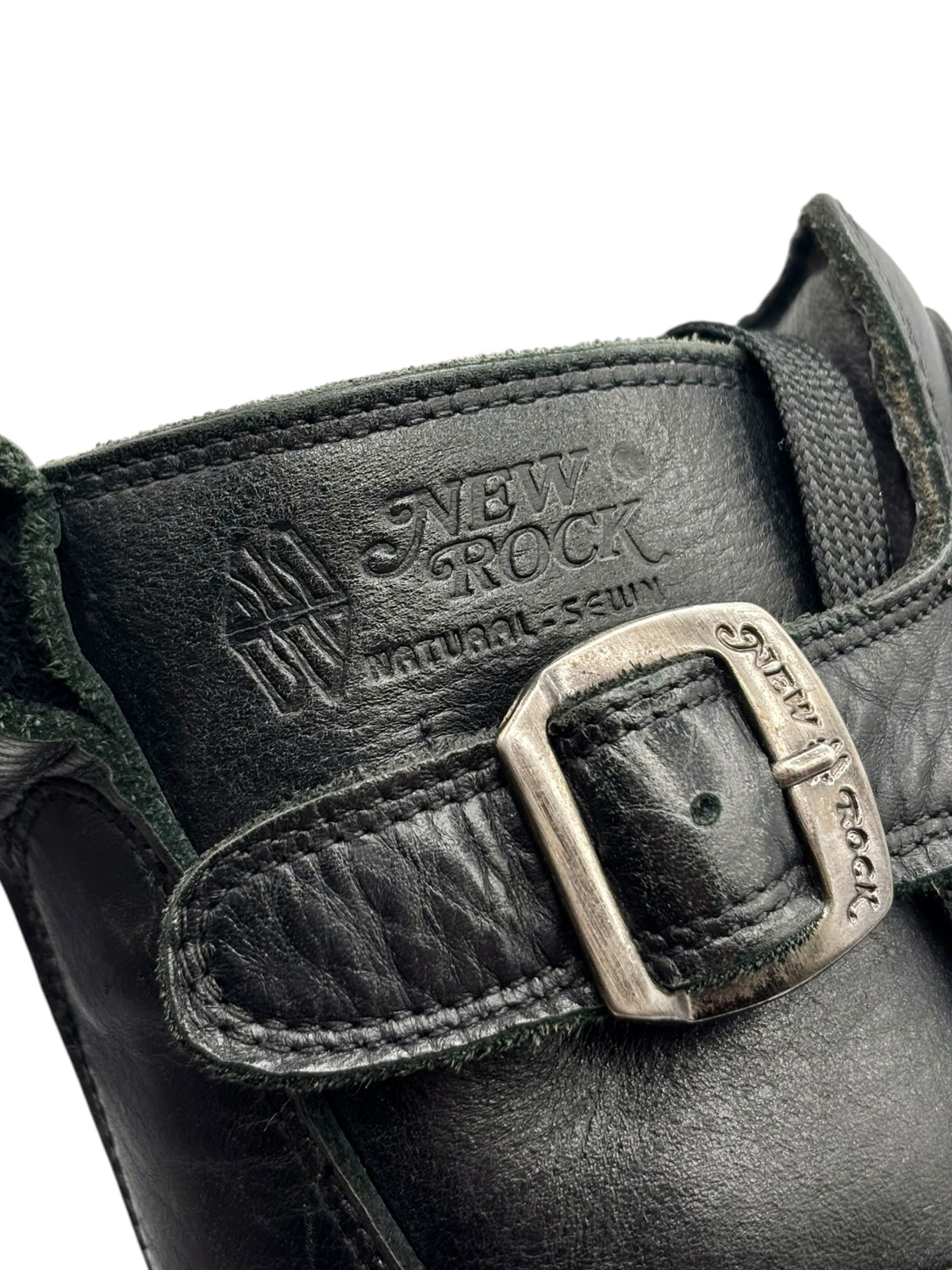Close-up of grey New Rock logo strap and metal buckle on the boot upper.