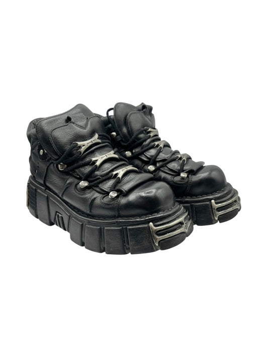 Black leather lace-up platform boots with metal hardware and chunky ribbed sole