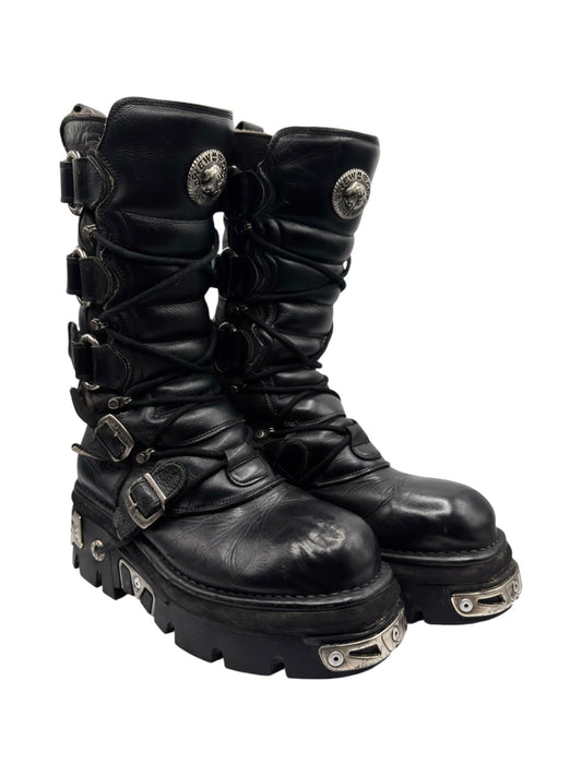 Knee-high black lace-up boots with side buckles and metal-trimmed sole hardware