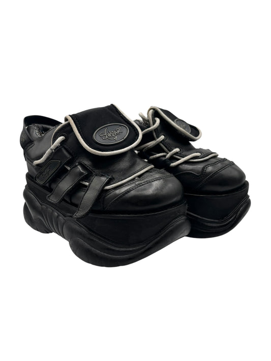Black leather lace-up platform boots with chunky sole and front strap details.